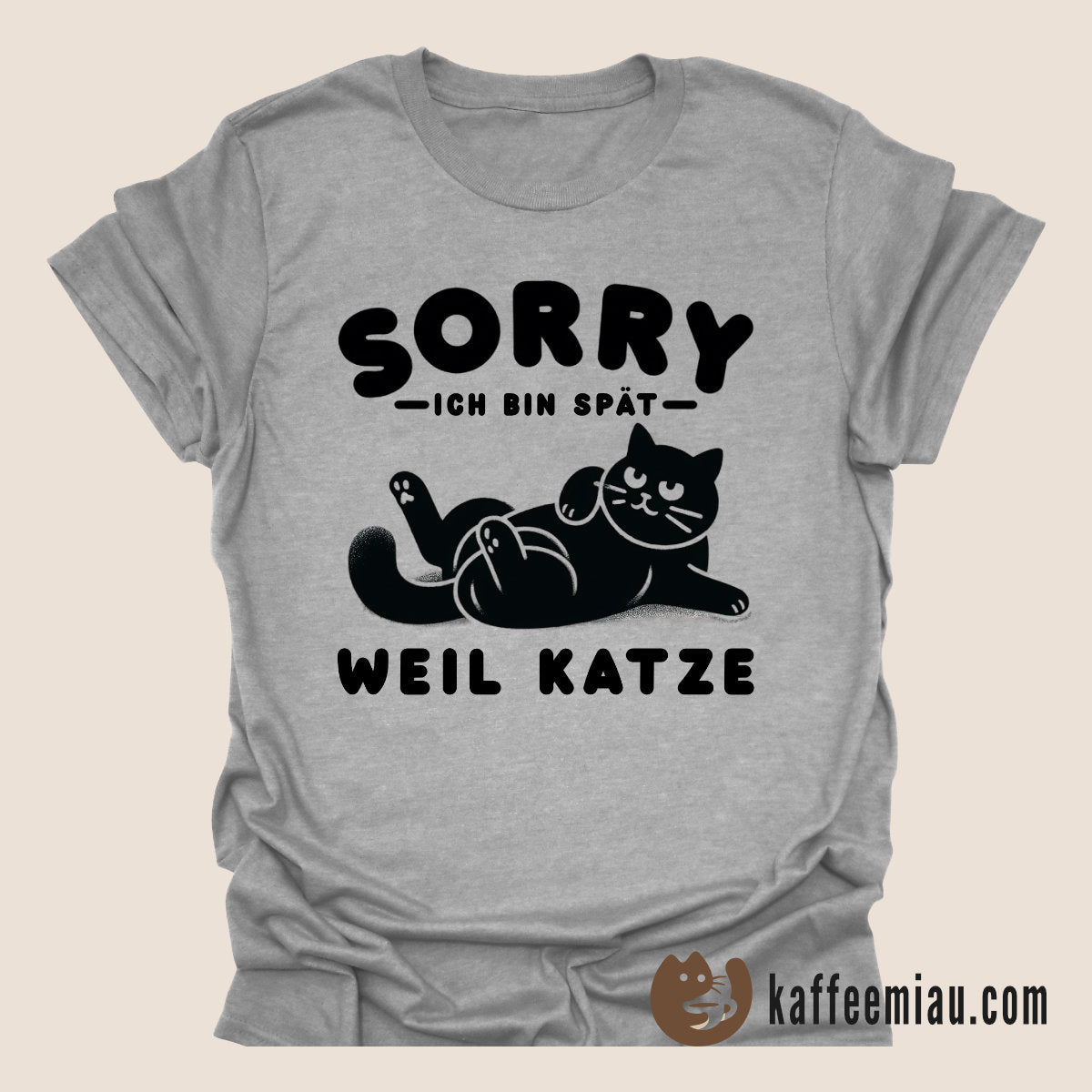 Graues T-Shirt mit einer schwarzen Katzenillustration und deutschem Text. Auf der rechten Seite wird ein Werbetext über T-Shirts aus Bio-Baumwolle mit Katzenmotiven angezeigt, mit einem Link zur Website kaffeemiaou.com.